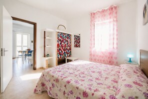 Una camera da letto con un letto, una scrivania, una sedia e un armadio.