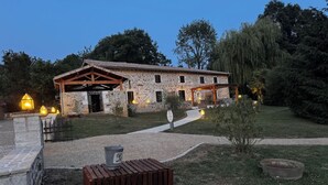 A stone building with a covered porch and a gravel pathway leading to it. - Gîte "La Prèze" - Deluxe 2 Bedrooms (n°4) (Rouzède)