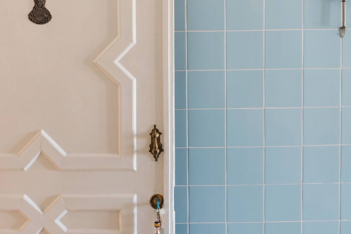 A door with a geometric pattern and a wall with blue tiles.