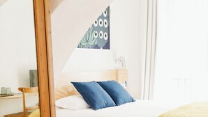 A bedroom with a bed, a wooden dresser, a mirror, and a wall-mounted artwork. - Botánico Casa Rural (Arcos de la Frontera)