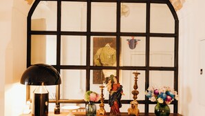 A wooden table with a lamp, vases, and a statue. - Botánico Casa Rural (Arcos de la Frontera)