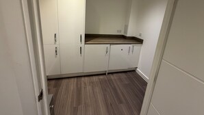 Une cuisine avec des armoires blanches, un plan de travail en bois et un plancher en bois.