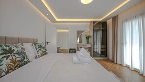 A modern hotel room with a large bed, a bedside table, a mirror, and a view of the hallway. - Murati Lake View Hotel (Farkë)