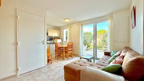 Ein Wohnzimmer mit einer Couch und einem Essbereich mit Tisch und Stühlen.