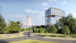 A modern hotel with a curved glass facade, a prominent crescent logo, and a parking area with cars and pedestrians. - The Crescent (Verona)