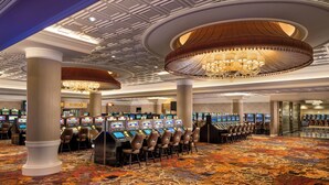 A casino with multiple gaming machines and a patterned carpet. - The Crescent (Verona)
