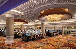 A casino with multiple gaming machines and a patterned carpet. - The Crescent (Verona)