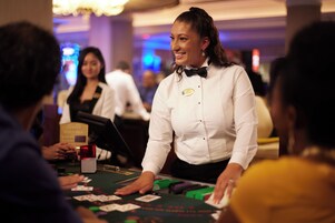 Un crupier de casino en una mesa de blackjack con jugadores.