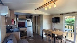 En kompakt bolig med tekøkken, spiseplads og opholdsområde med sofa og sofabord.