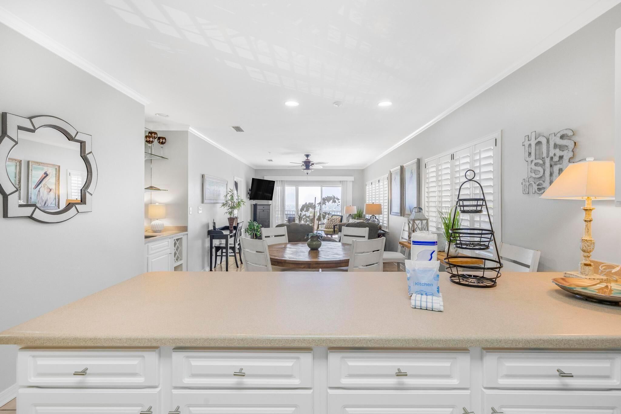 A modern kitchen with a central island, white cabinetry, and a dining area with a round table.