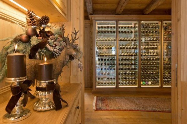 A wooden interior with a glass display case filled with wine bottles. - Burg Vital Resort (Bludenz)