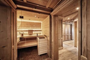 A wooden sauna with a bench, a sink, and a small window. - Burg Vital Resort (Bludenz)