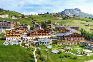 A mountain resort with multiple chalet-style buildings, a central courtyard, and a backdrop of mountains. - Burg Vital Resort (Bludenz)