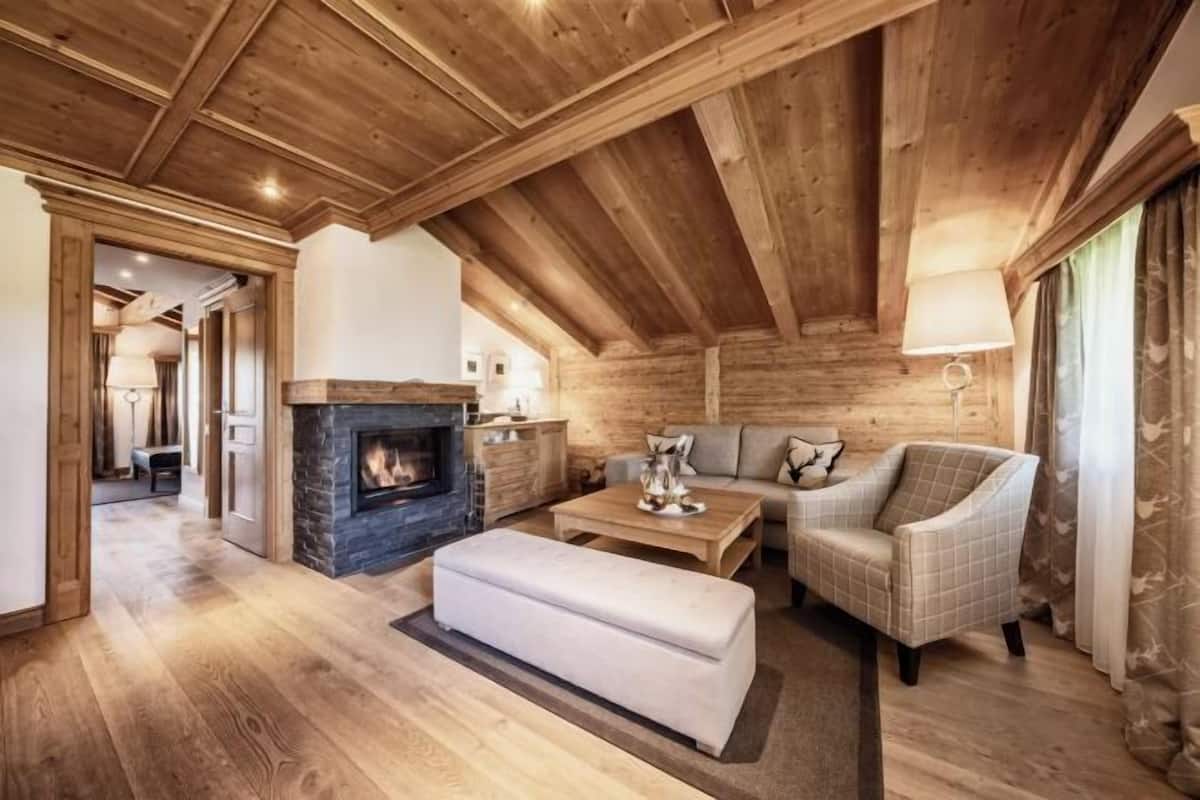 Ein gemütliches Wohnzimmer mit Kamin, Holzboden und einer Couch.
