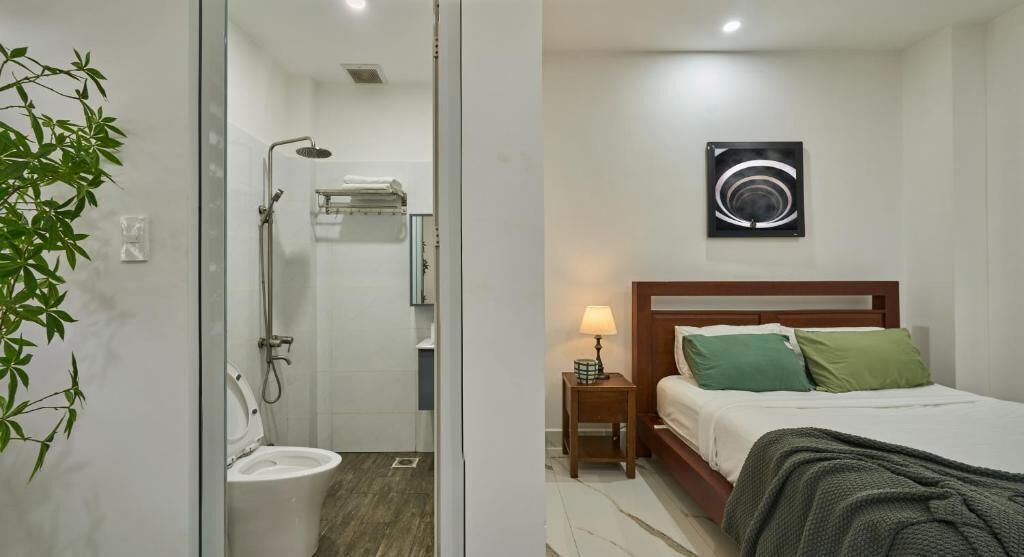 A modern bedroom with a bed, bedside table, and a wall-mounted abstract art piece.