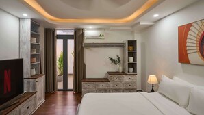 A modern hotel room with a bed, a TV, a wardrobe, a desk, and a window. - Green Riverside Hotel (Ho Chi Minh City)