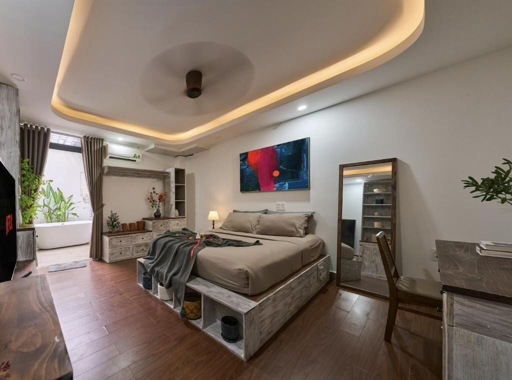 Ein modernes Schlafzimmer mit einem Bett, Nachttischen, einem Schreibtisch und einem großen Spiegel.