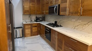 Una cucina moderna con mobili in legno, un forno a microonde, un piano cottura e un lavello.