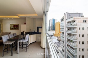 Un apartamento moderno con comedor, cocina y ventanas amplias con vistas a la ciudad.