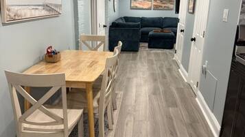 A modern interior with a dining area, a sofa set, and a kitchen.