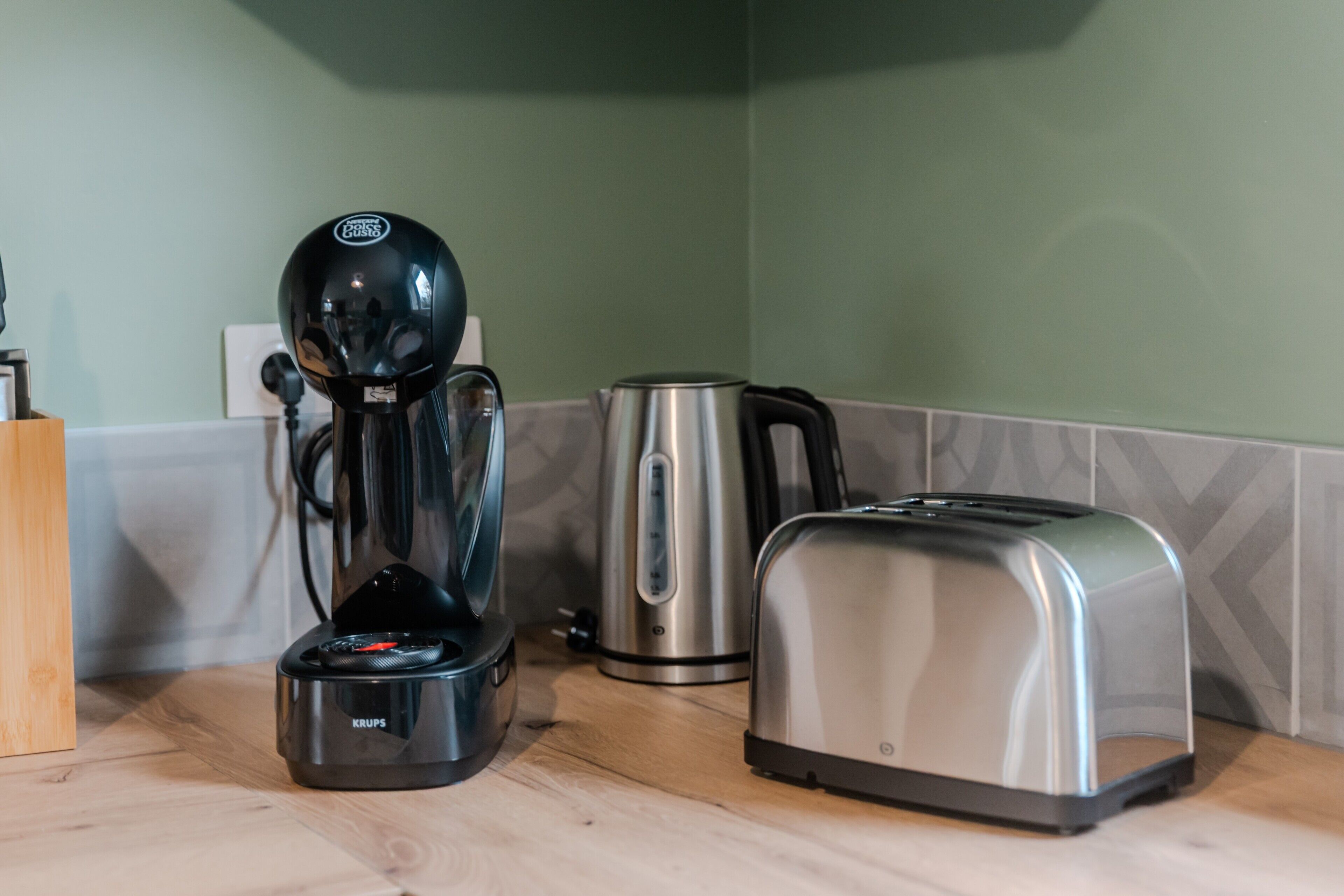 A coffee maker, a toaster, and a kettle on a kitchen counter.