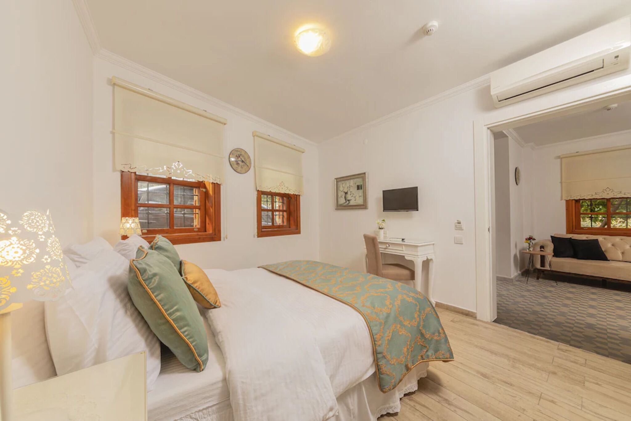 Ein Schlafzimmer mit Bett, Schreibtisch, Stuhl und einer Couch.