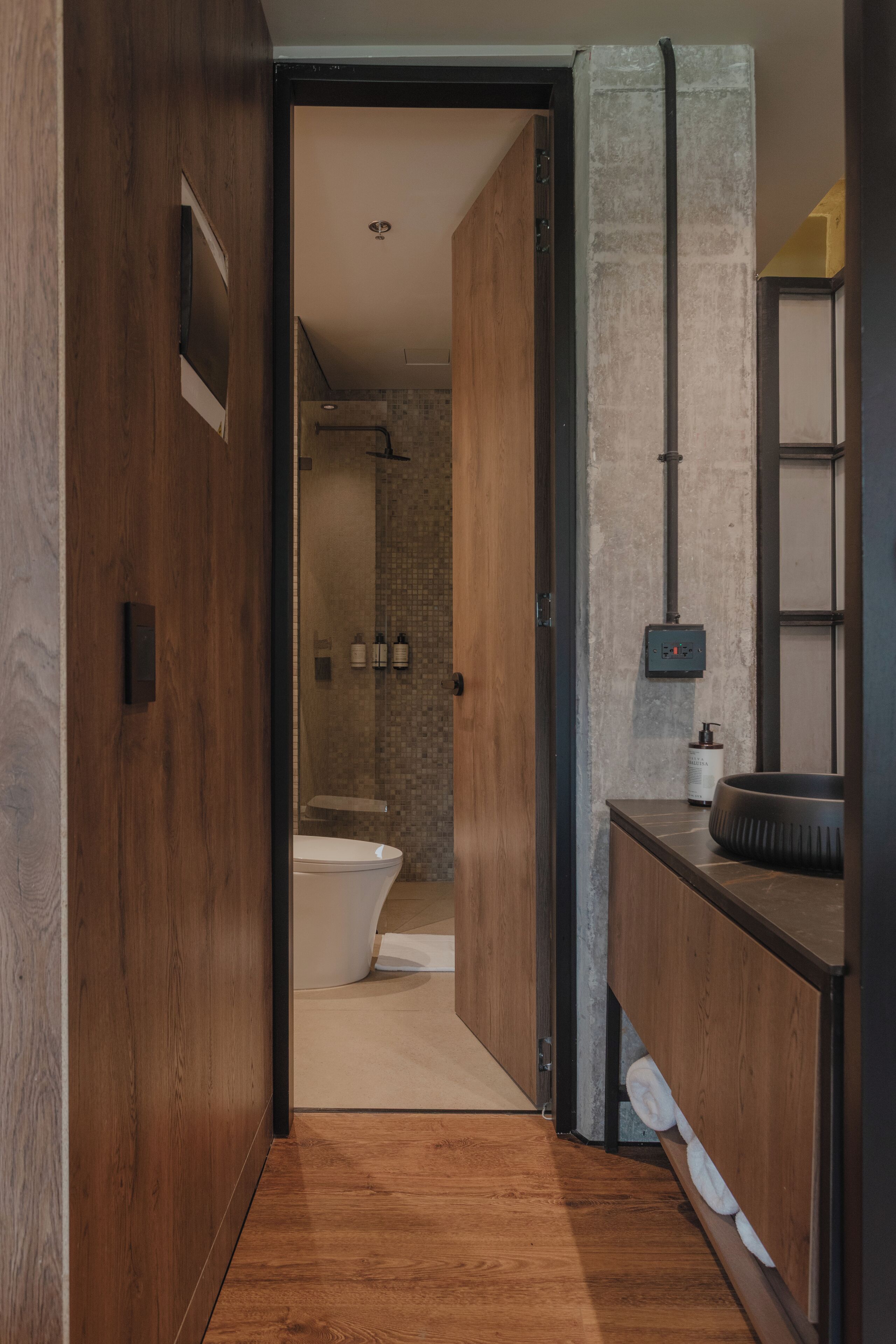 Une salle de bain moderne avec un meuble-lavabo en bois, une baignoire et un espace douche.