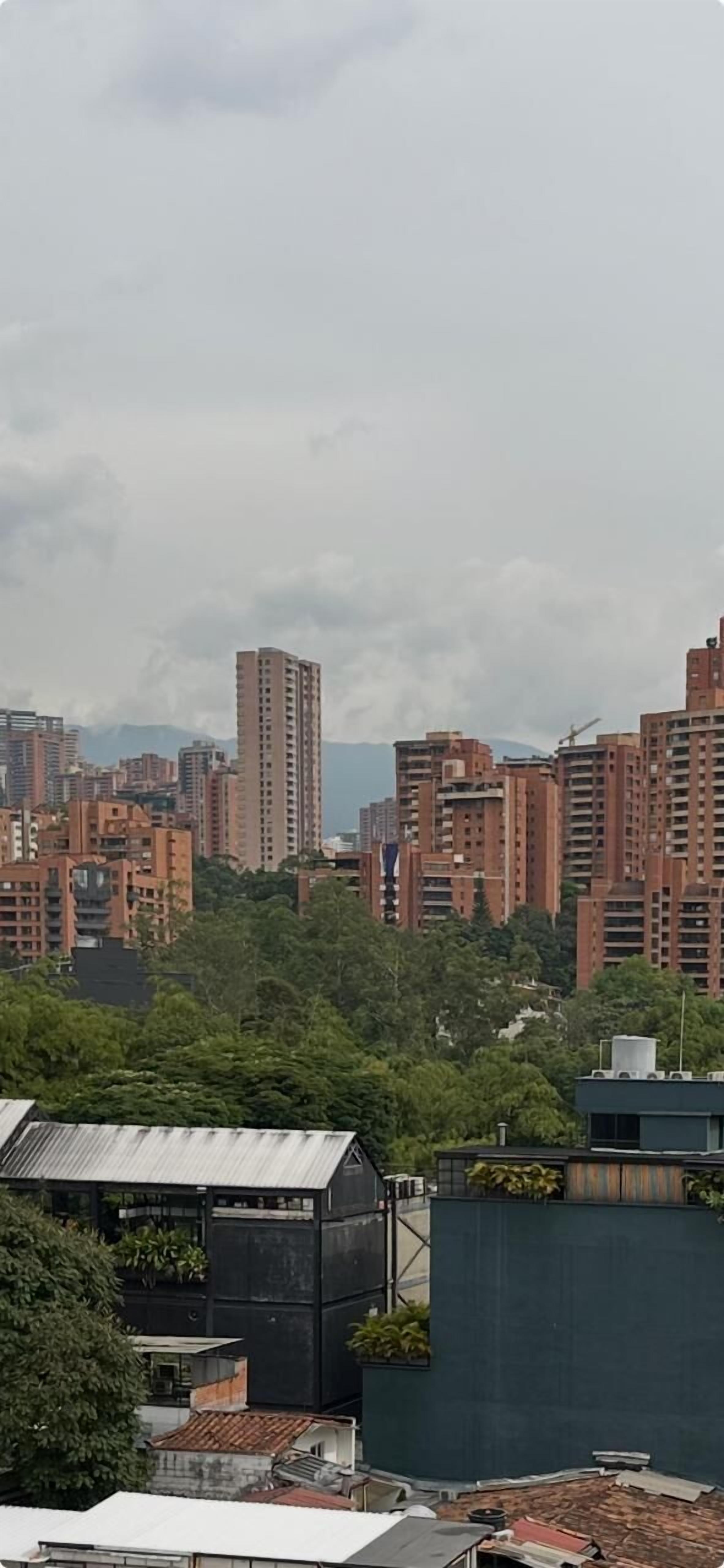 Un paisaje urbano con edificios altos, una grúa de construcción y una combinación de estructuras residenciales y comerciales.