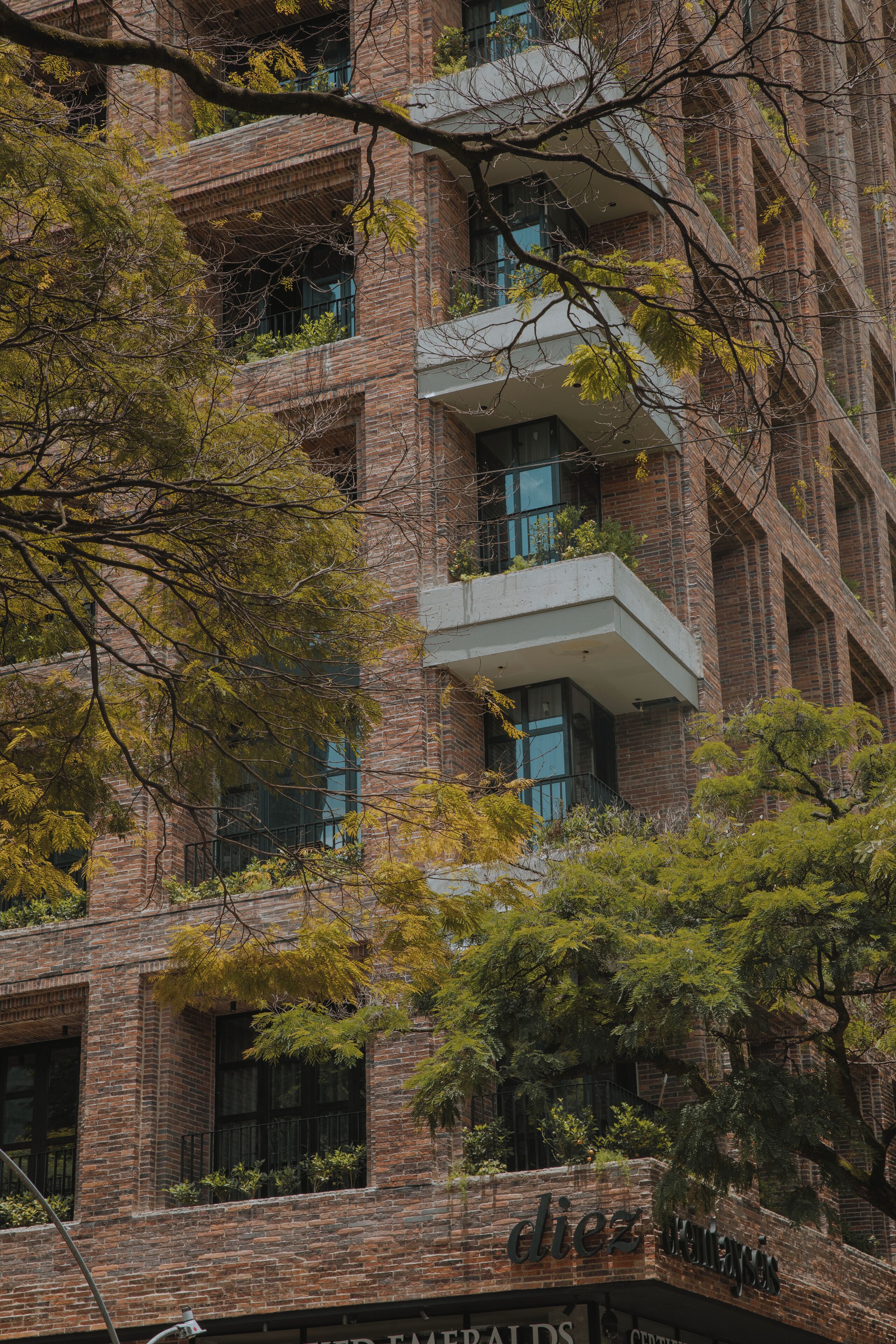 Un immeuble à plusieurs étages, doté d’une façade en briques, de balcons et d’une enseigne sur laquelle on peut lire le mot « dix ».