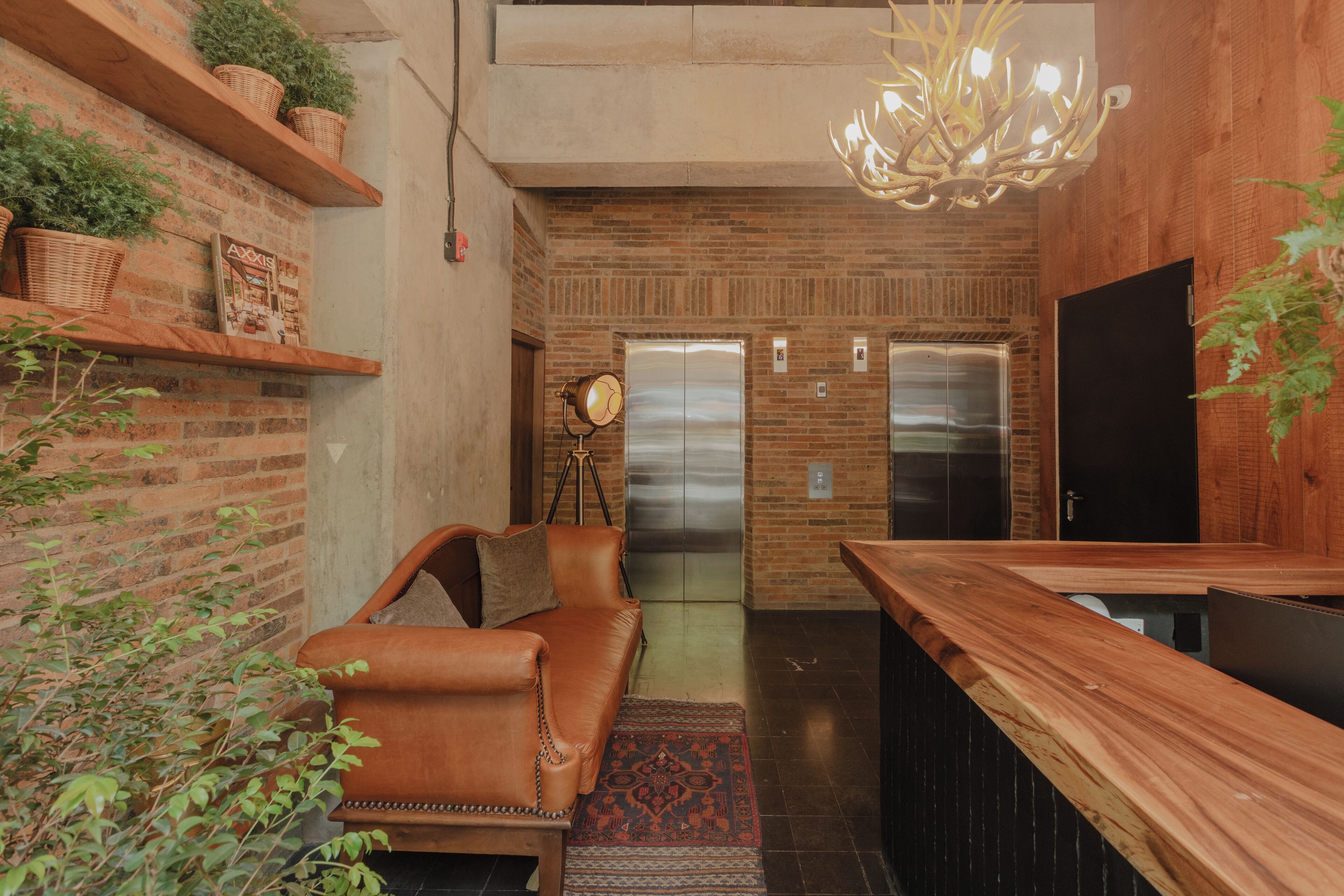 Una cocina moderna con encimera de madera, sofá de cuero y pared de ladrillo con estanterías.