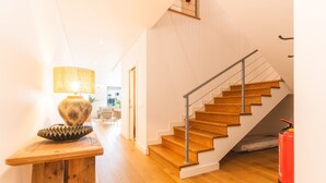 Una escalera con escalones de madera y barandilla de metal, que conduce a un piso superior.