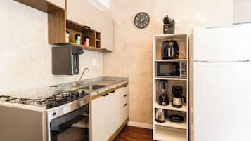 Appartement | Privékeuken | Een magnetron, een kookplaat, kookgerei, borden en bestek