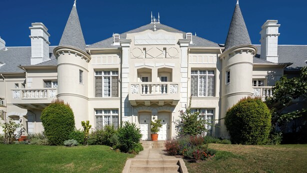 A large, stately building with two symmetrical towers, a central entrance with a balcony, and a well-maintained front lawn. - Chateau Beachwood (Los Angeles)