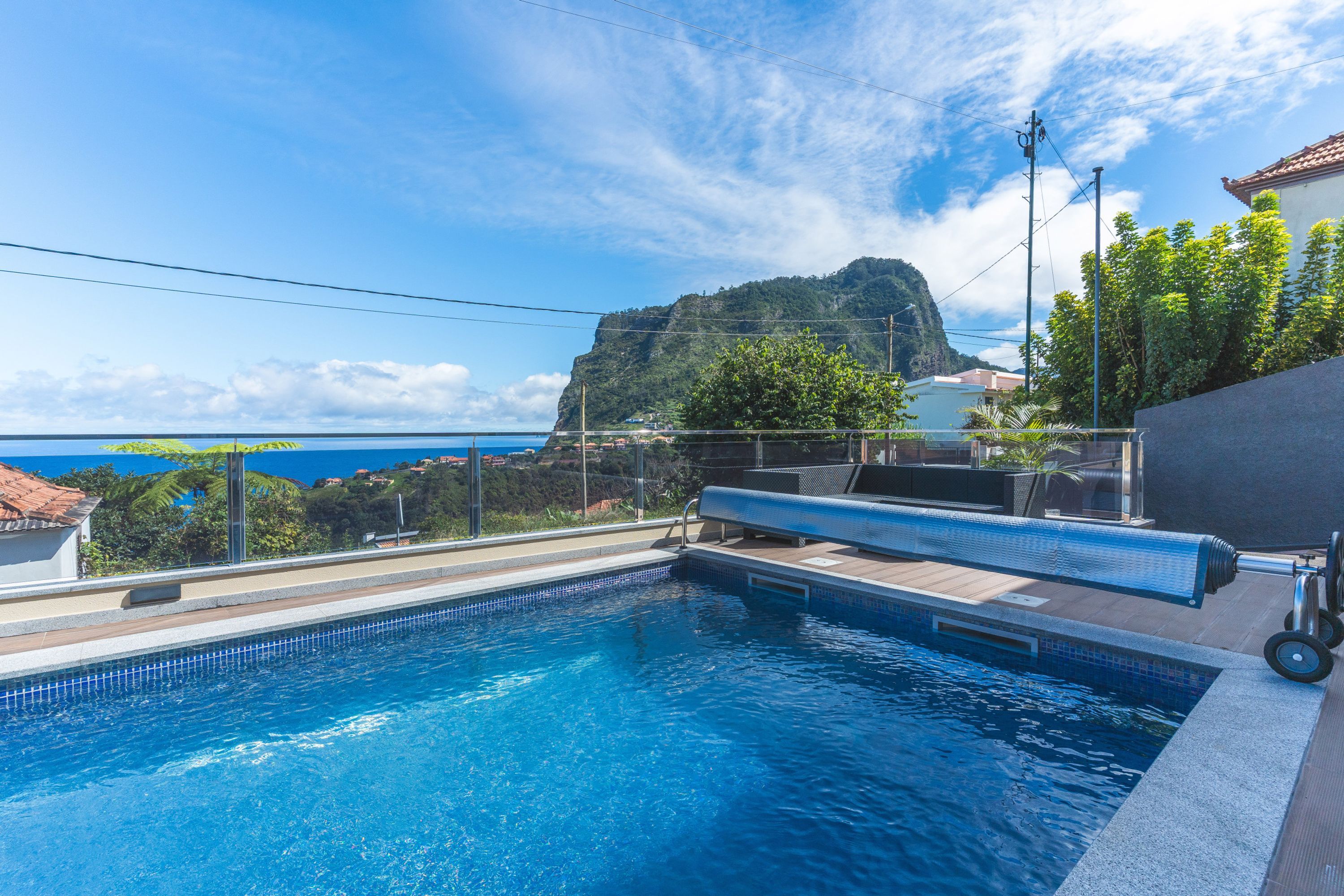 Una piscina con vistas a una montaña y al mar.