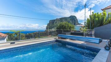 Una piscina con vistas a una montaña y al mar.