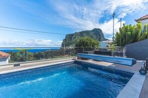 Una piscina con vistas a una montaña y al mar.