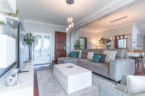 A modern living room with a sofa, coffee table, and decorative plants.