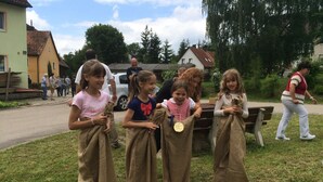 A group of children playing with sacks in a grassy outdoor area. - Apartment on a horse farm, children and pets welcome, garden & terrasse, grill (Lichtenau)