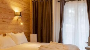 Una habitación con paneles de madera, una cama, una silla y una lámpara.