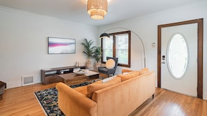 Ein modernes Wohnzimmer mit einer Couch, einem Couchtisch, einer Lampe und einer Tür mit Milchglasfenster.