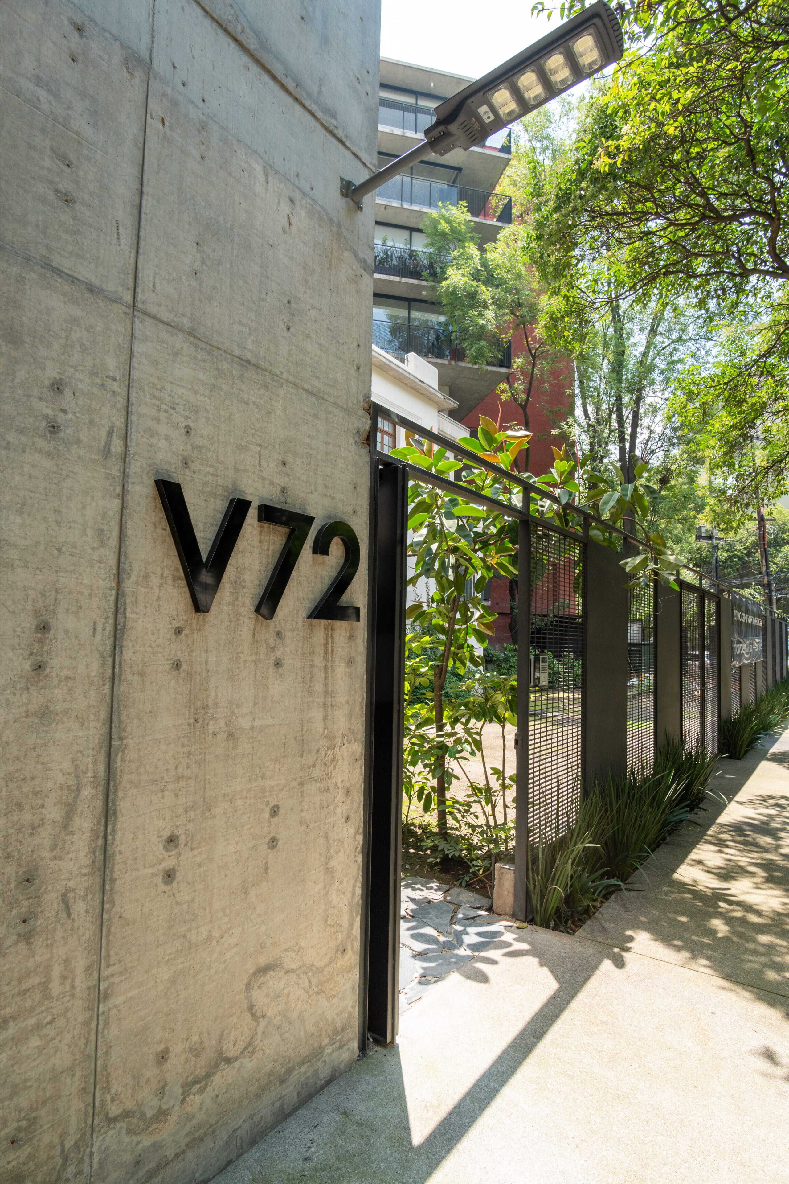 Un mur en béton portant le numéro « V72 », qui désigne une propriété ou un lieu.