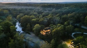 Une vue aérienne d’une zone boisée, avec une cabane entourée d’arbres denses.