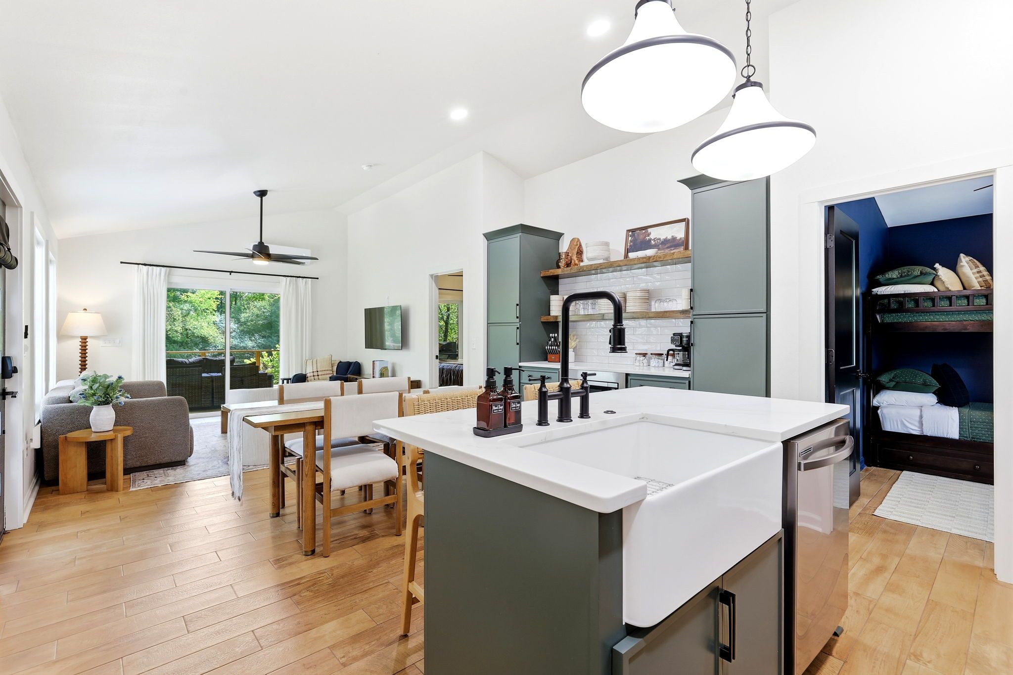A modern kitchen with a central island, built-in appliances, and pendant lighting.