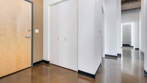 A hallway with a wooden door, white closets, and a polished floor. - Modern West Loop Gem-City Views & Prime Location 1 (Chicago)