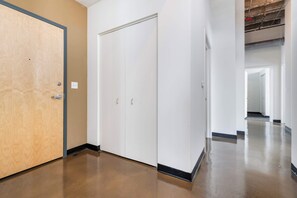 A hallway with a wooden door, white closets, and a polished floor. - Modern West Loop Gem-City Views & Prime Location 1 (Chicago)