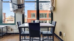 A room with a large window, a table, and four chairs. - Modern West Loop Gem-City Views & Prime Location 1 (Chicago)