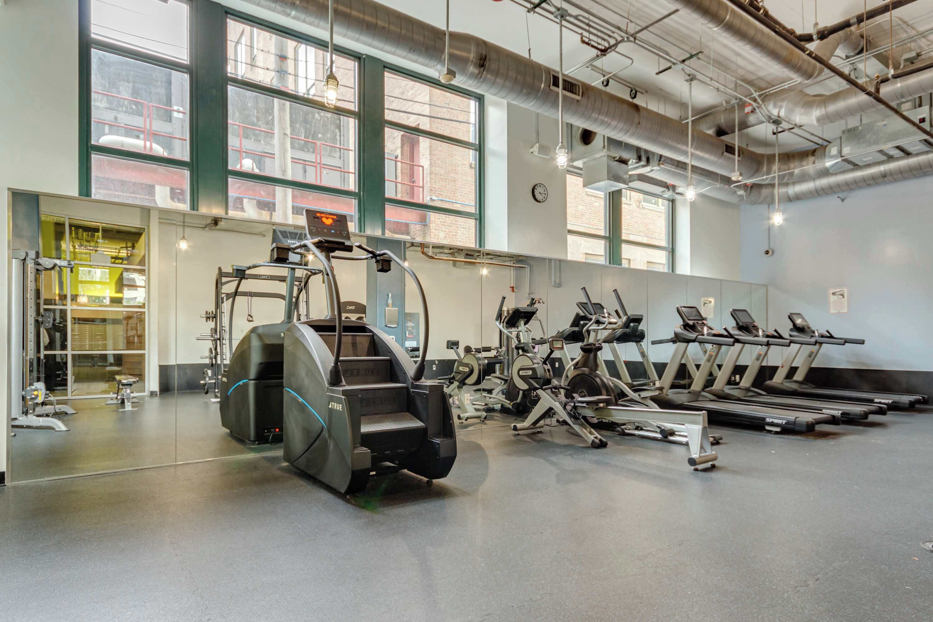 A gym with treadmills, ellipticals, and weight machines.