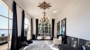Un salon moderne avec une grande fenêtre, un lustre et un canapé.