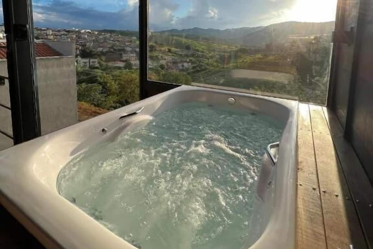A hot tub with a view of a mountainous landscape.