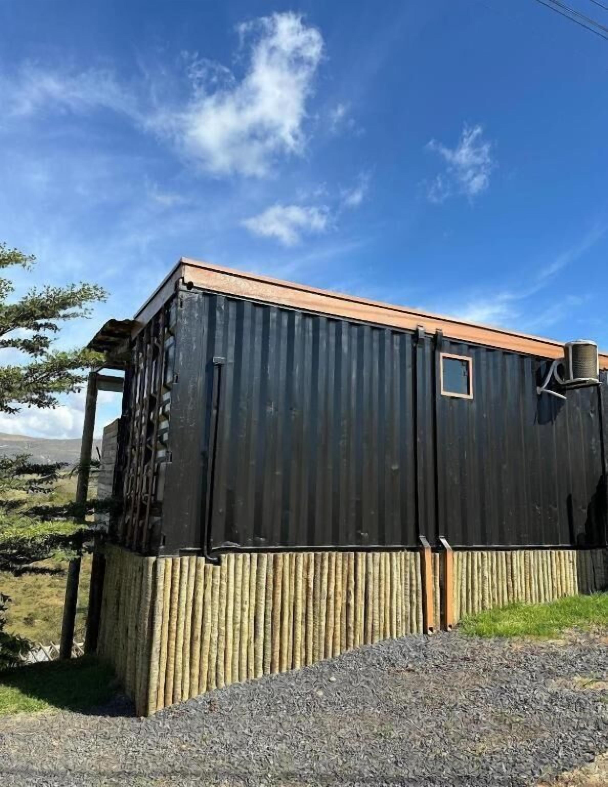 A small, single-story building with a corrugated metal exterior and a wooden base.